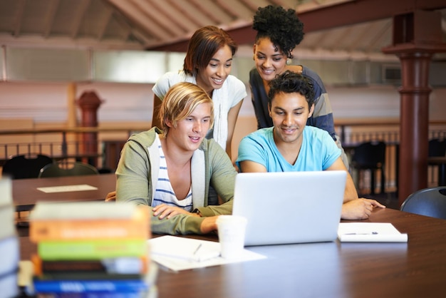 Teamwork laptop or group of students studying in university college or school campus for education Library elearning or happy people with scholarship reading news research or online course