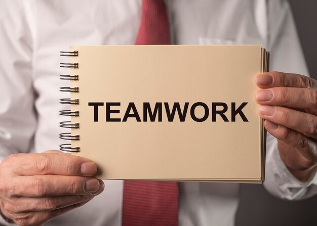 Teamwork word in businessman hands. Concept of working together in community.