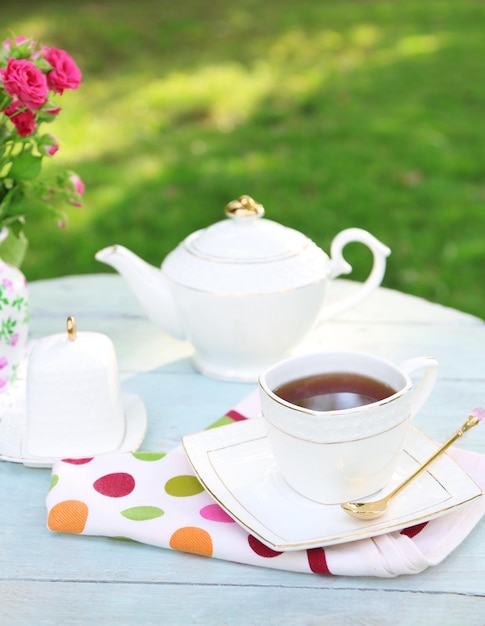 Teapot and cup on table closeup in garden