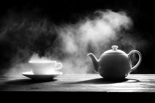 Photo a teapot and a cup of tea on a table with a cup of tea