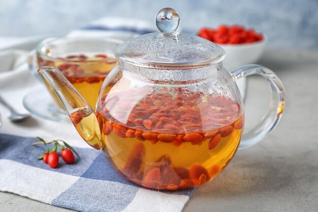 Teapot with goji tea on table