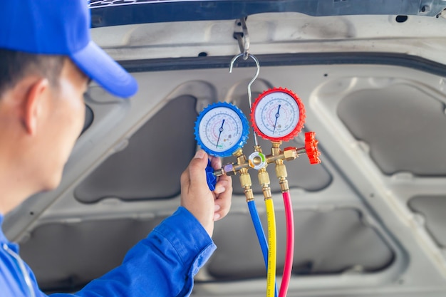 Technician check car air conditioning system refrigerant recharge Repairman holding monitor tool to check and fixed car air conditioner system Air Conditioning Repair