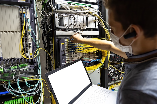 Technician engineer fixing problem with servers and data in cables room