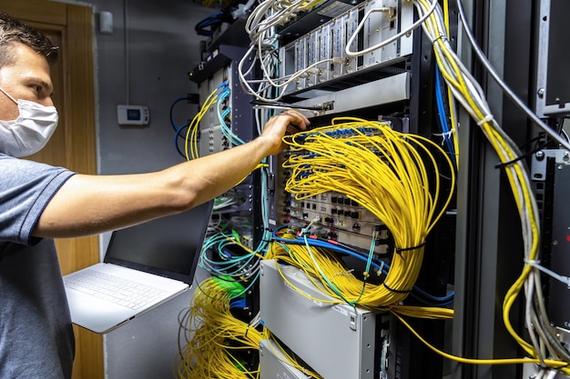 Technician engineer fixing problem with servers and data in cables room