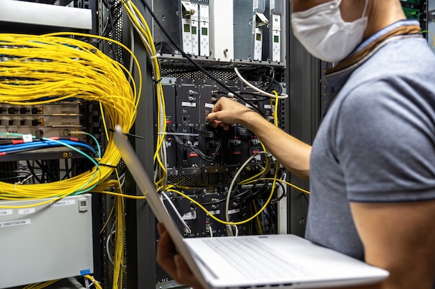 Technician engineer fixing problem with servers and data in cables room