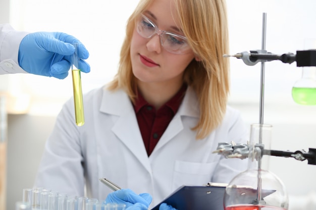 Technician hold in arms in protective gloves sample bottle with poison fluid portrait.