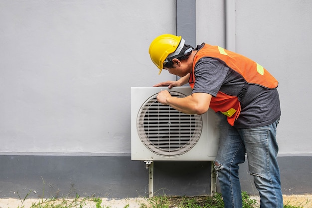 The technician is fixing the air conditioner.