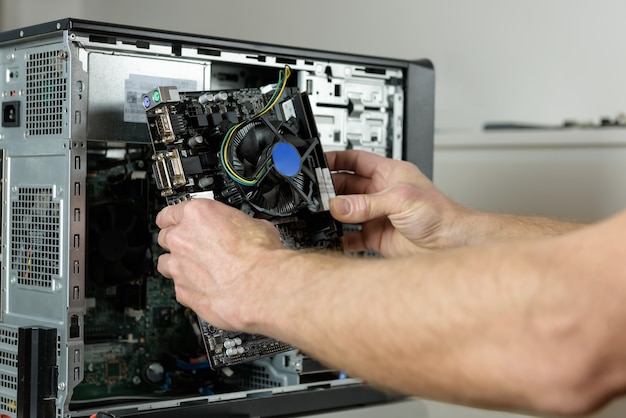 A technician is installing the motherboard in the desktop case close up