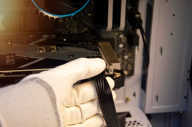 Technician repairing computers connecting wires to computers