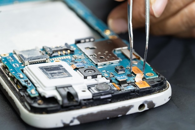 Technician repairing inside of mobile phone by soldering iron Integrated Circuit the concept of data hardware technology