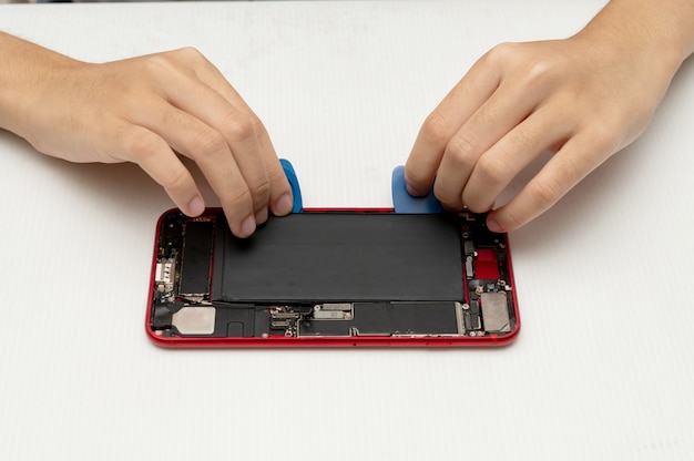 Technician replaces the battery of a cell phone or smartphone.