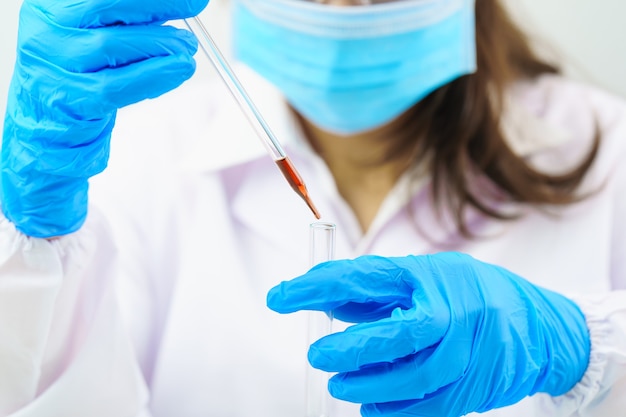 technician scientist analyzing a blood sample in test tube testing it coronavirus virus analysis