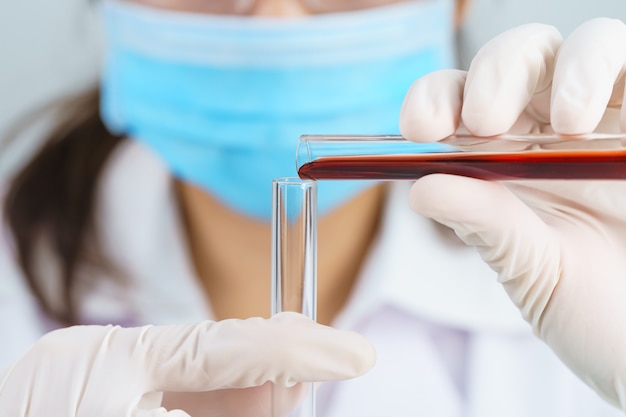 Technician scientist analyzing holding blood sample in test tube in laboratory for testing