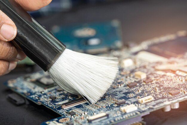 Technician use brush and air blower ball to clean dust in circuit board computer Repair upgrade and maintenance technology