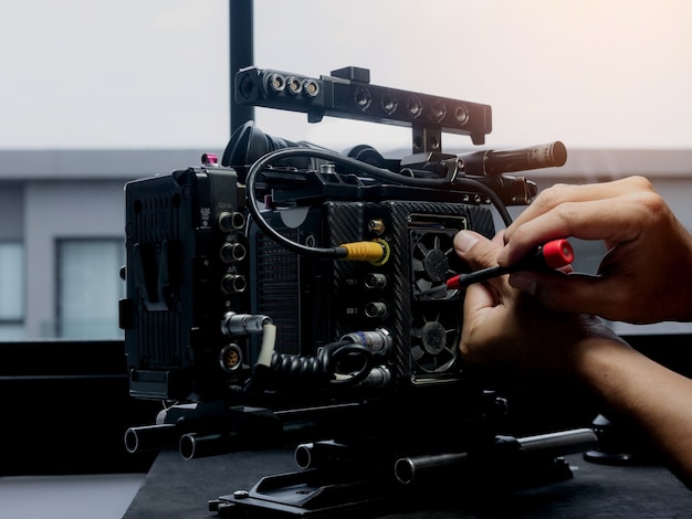 Technician using a screwdriver to changing the cooling fan of the movie camera.