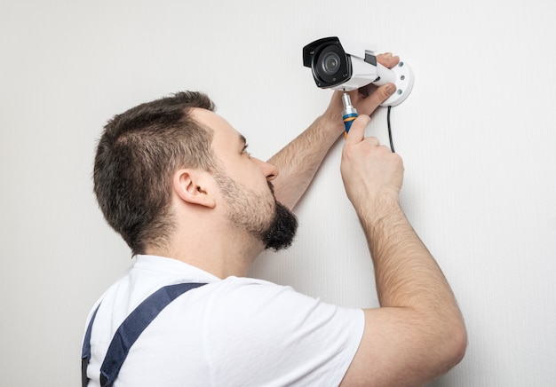 Technician worker installing video surveillance camera