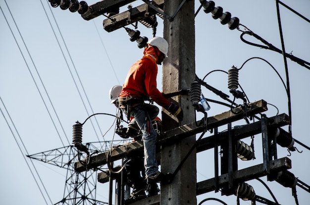 Technicians are repairing high voltage transmission systems on the power poles.