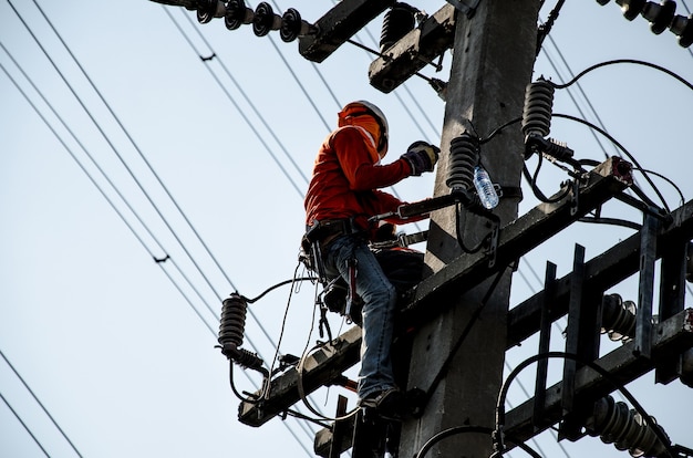 Technicians are repairing high voltage transmission systems on the power poles.