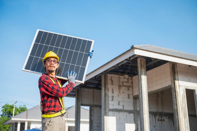 Technicians carrying solar panels ready to be installed on the roof of a housing estate energysaving and costsaving concept Own a small business installing solar panels