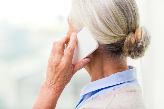 technology, communication, age and people concept - close up of senior woman with smartphone calling at home