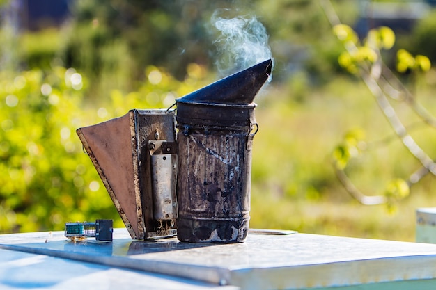 Technology of fumigation of bees. Intoxicating smoke for safe honey production. Old bee smoker. Beekeeping tool.