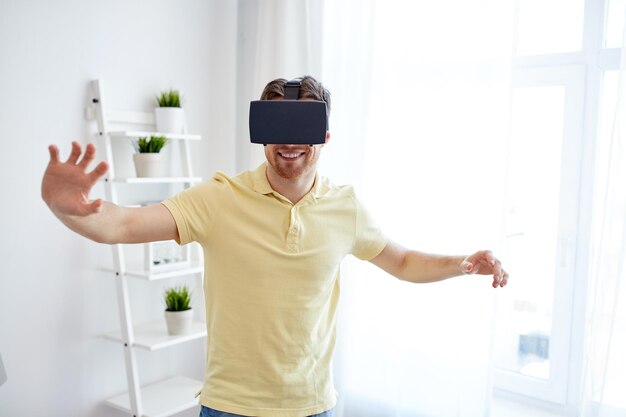 technology, gaming, entertainment and people concept - happy young man with virtual reality headset or 3d glasses playing video game