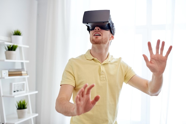 technology, gaming, entertainment and people concept - young man with virtual reality headset or 3d glasses playing video game