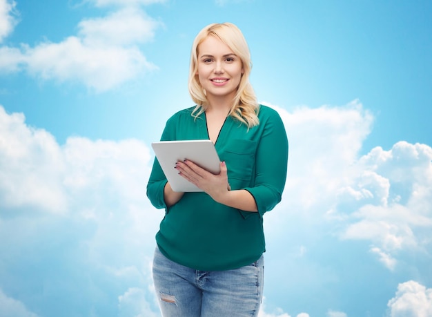 technology, internet and people concept concept - smiling woman with tablet pc computer over blue sky and clouds background