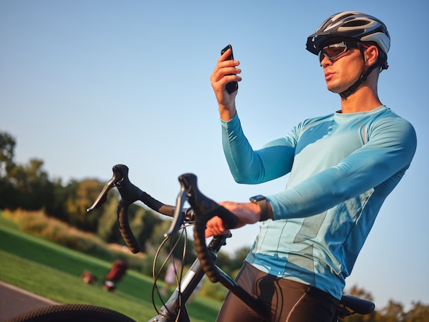 Technology professional young male cyclist wearing sportswear protective helmet and glasses holding