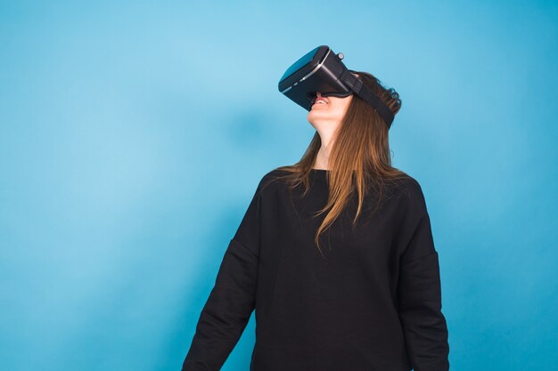 Photo technology, virtual reality, entertainment and people concept - happy young woman with virtual reality headset or 3d glasses.