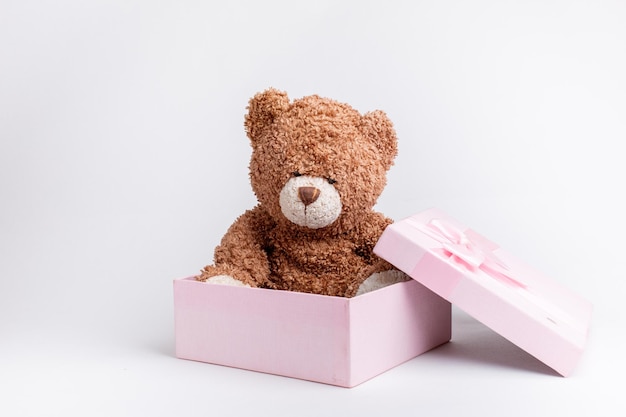 Teddy bear in a pink gift box on a white background isolated