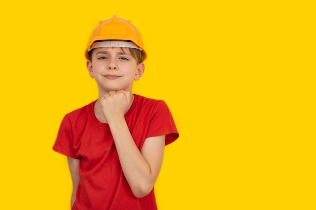 Teen boy in hard hat on yellow background Choice of profession Copy space