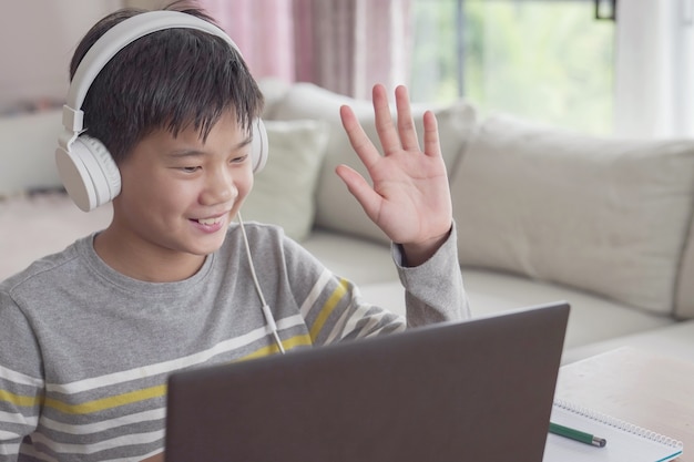 teen boy making video calling with laptop at home, homeschooling, learning remotely concept