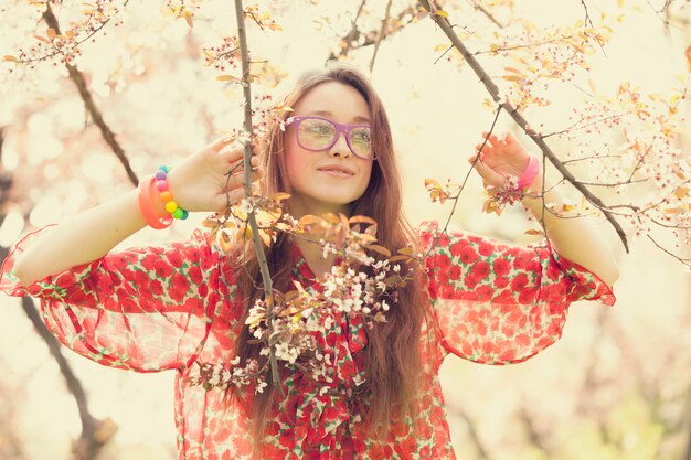 Photo teen girl in glasses near blossom tree