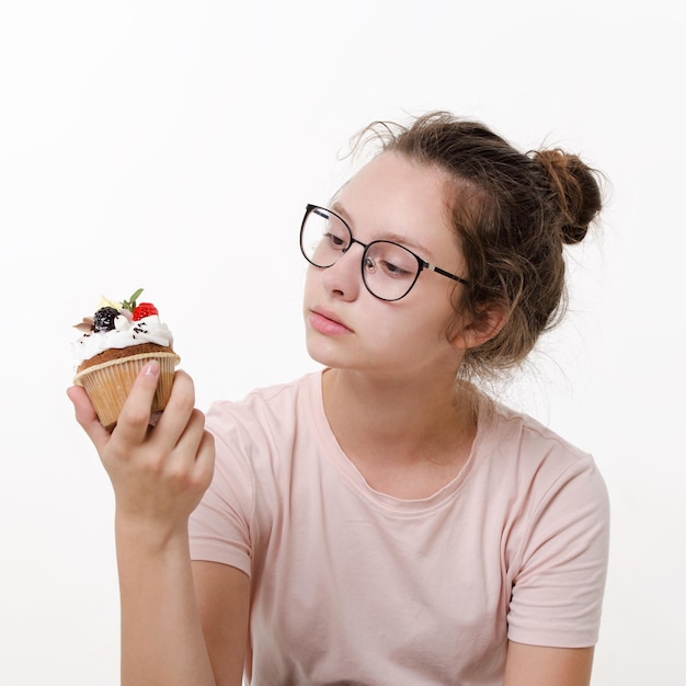 Teen girl holds sweet cream cake in her hand and wants to eat white background