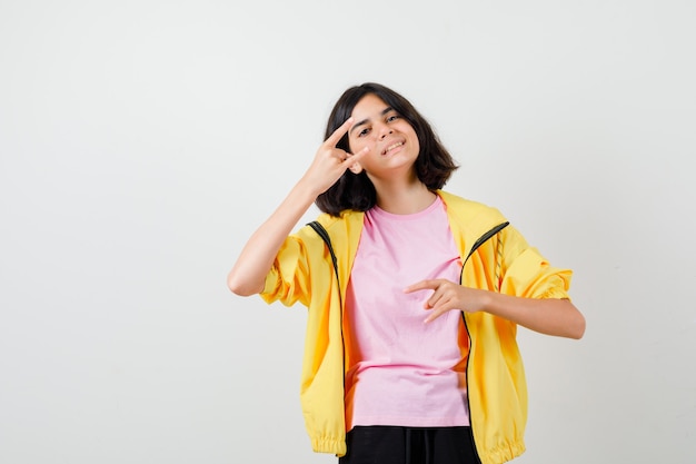 Teen girl showing rock n roll gesture in t-shirt, jacket and looking cheerful , front view.