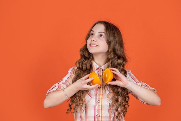 Teen girl smile hold citric fruit on orange background