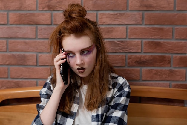 Teen girl with red hair and bright makeup generation z