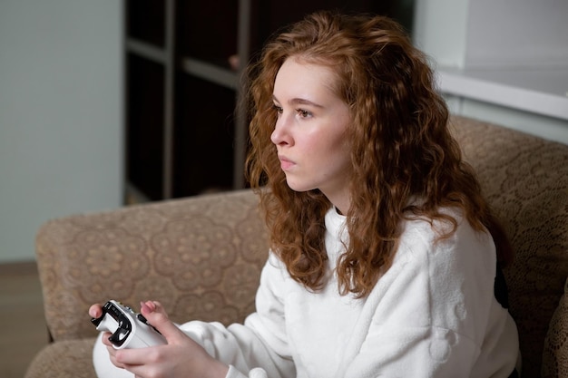 Teen girl with red hair, Generation Z, playing a video game