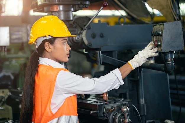 Teen girl working with lathe metal work shop steel factory industry engineer machine operator