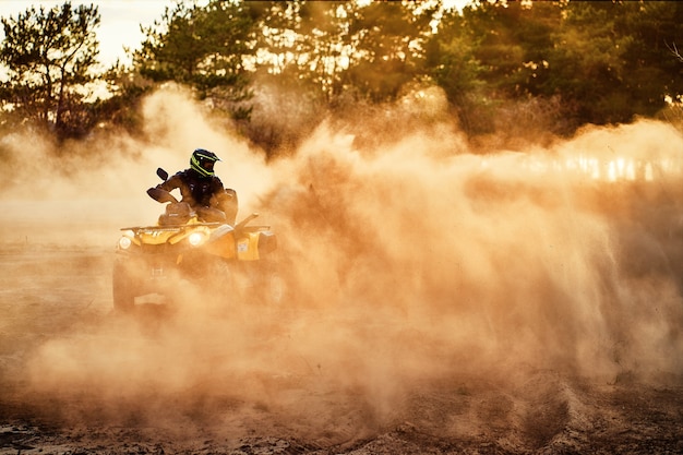 Photo teen riding atv in sand dunes making a turn in the sand