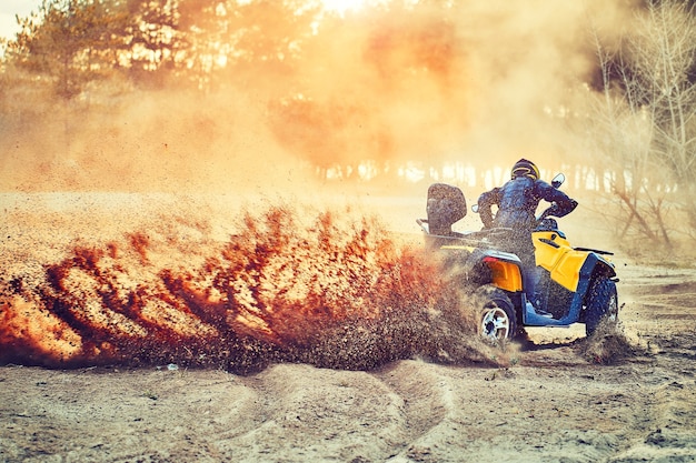 Photo teen riding atv in sand dunes making a turn in the sand