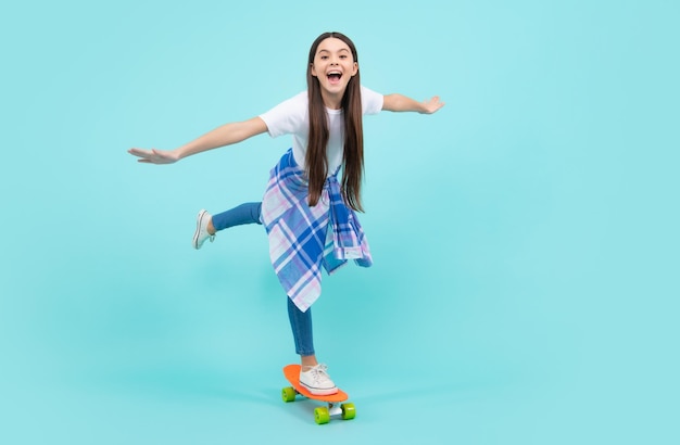 Teen school girl with skateboard on studio isolated background Schoolgirl spring trend urban teenager style Happy teenager positive and smiling emotions of teen girl