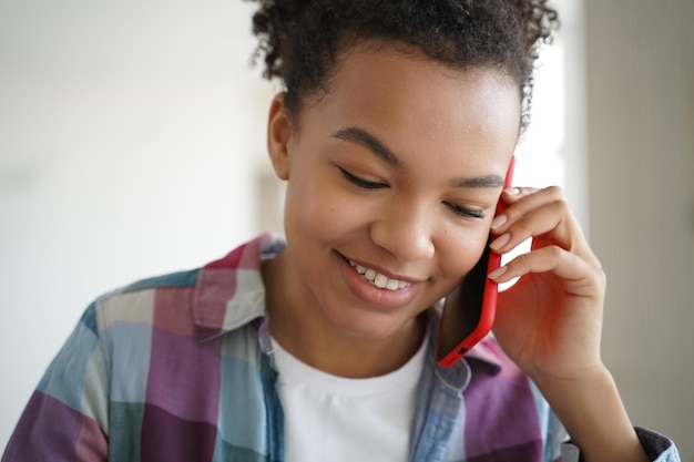 Teenage african american girl talking on cellphone to friend Teenager is gossiping and flirting