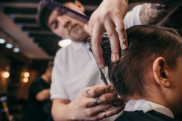 Teenage boy haircuts hairdresser in Barber shop