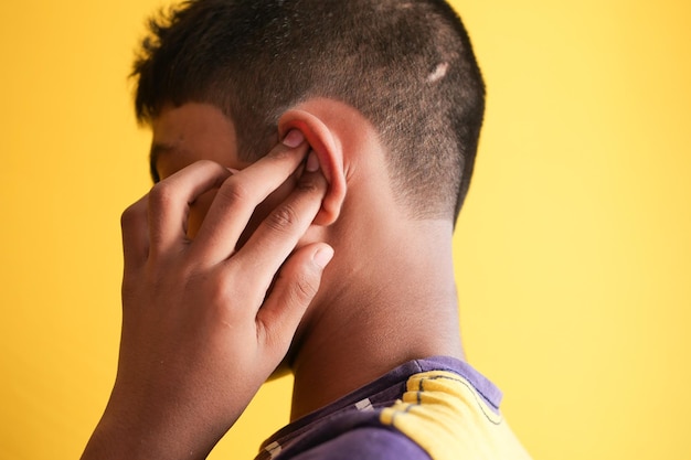 Teenage boy having ear pain touching his painful ear