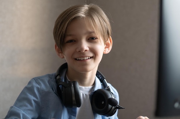 A teenage boy is sitting at home at the computer and playing computer games online.