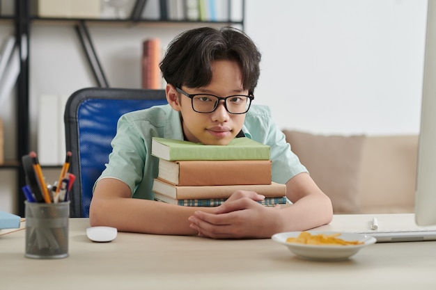 Teenage Boy Leaning on Books Stack