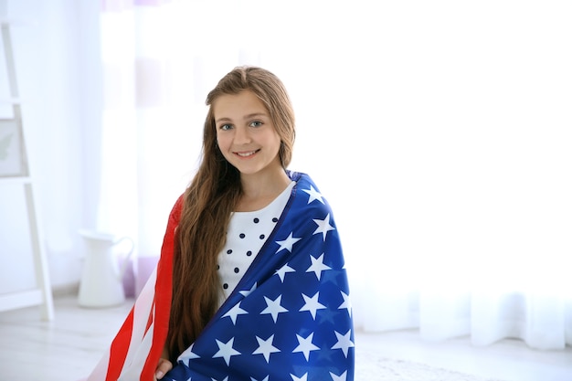 Teenage girl and American flag in room