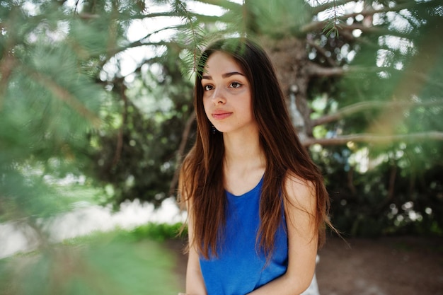 Teenage girl in blue dress posed outdoor at sunny day